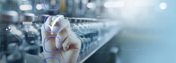 istock a hand marking checkboxes against a blurred industrial background, symbolizing quality control and process management. The digital overlay and futuristic elements highlight the integration of technology 2161724222