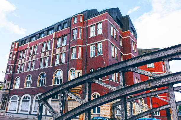 Brick residential building and metal bridge in Hamburg, Germany. Footbridge over a street in the city