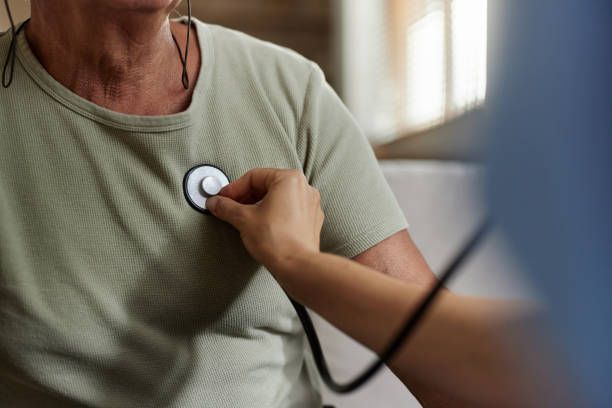 Close up of unrecognizable female doctor listening to man's heartbeat with a stethoscope.