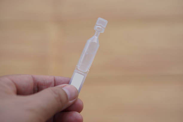 Single use artificial tear lubricant eye drops container, tube, isolated on brown  background. Concept, medical products for dry eyes or eyes disease treatment.