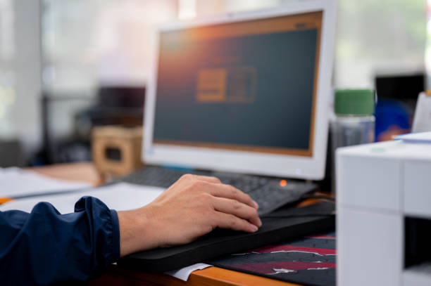istock Male office worker's hand holding a mouse to use a desktop computer. 2161728705