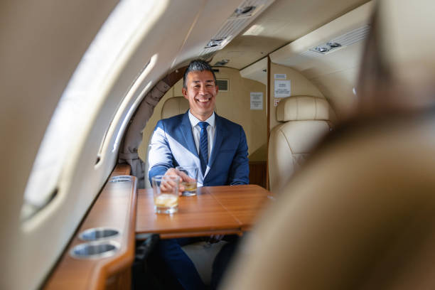 istock Cheerful Businessman Enjoying a Drink on a Private Jet 2161728743