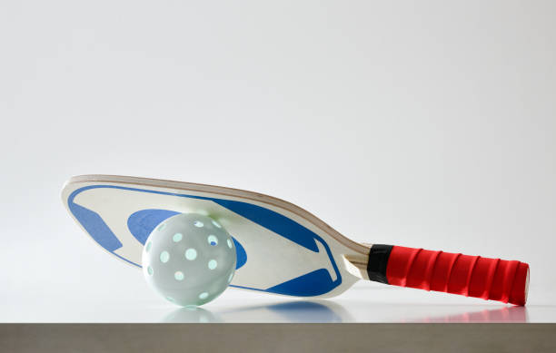 istock Pickleball paddle on ball reflected on white table isolated background 2161728909