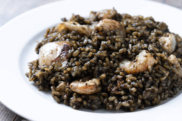 istock Black rice with seafood in plate on wooden table 2161730857