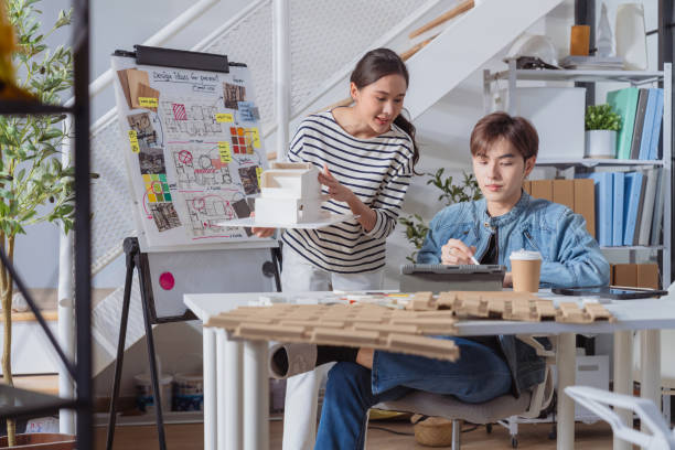 Meeting in a modern architectural office asian architect and interior designer working creative space planing design discuss brainstorm ideas sharing together Architect Team working best solution