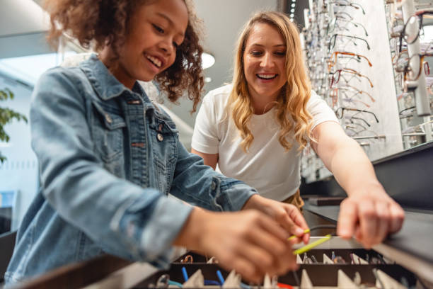 istock Young Girl Selecting Eyeglasses In The Optical Store 2161734065