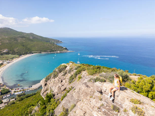 istock Relaxed Hiker Sitting on Cliff with Coastal View 2161735575