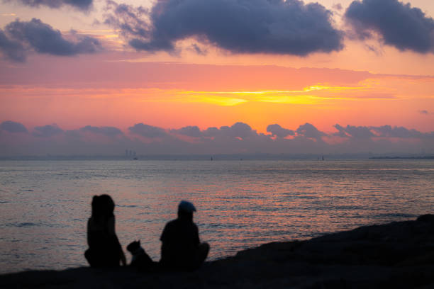 Beautiful sunset landscape with two women at coastline.