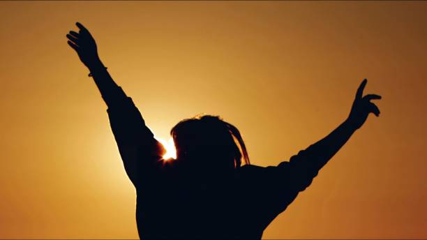 istock Young Woman Silhouette in Sunset 2161741040