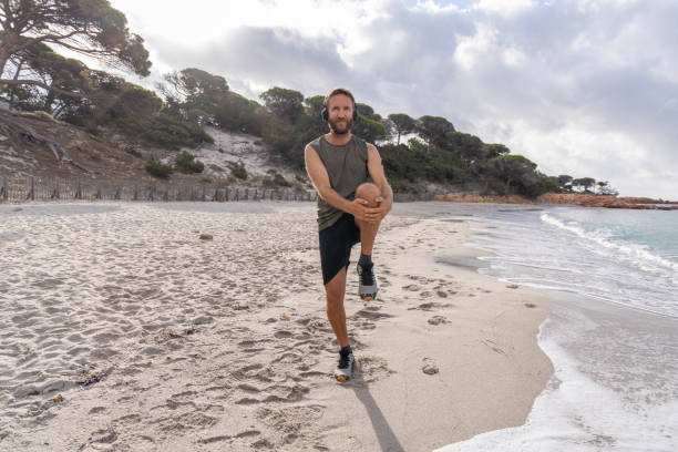 istock Morning Routine: Man Stretching on the Beach with Headphones On 2161744111