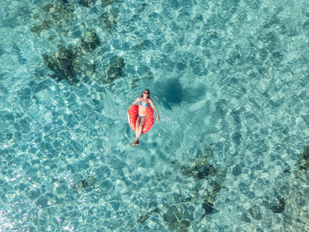 istock Woman Relaxing on Float in Clear Blue Waters 2161745055