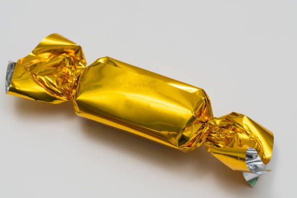 istock Delicious candy in golden wrapper isolated on white 2161745245