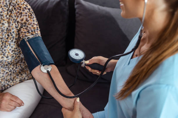 istock Nurse checking patient's blood pressure at home 2161747868