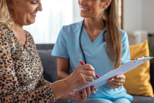 istock Nurse assisting elderly woman with paperwork at home 2161747878