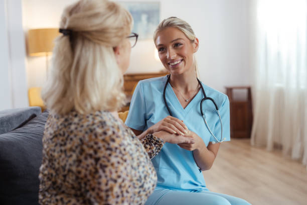 istock Nurse comforting elderly patient at home with a warm smile 2161747899