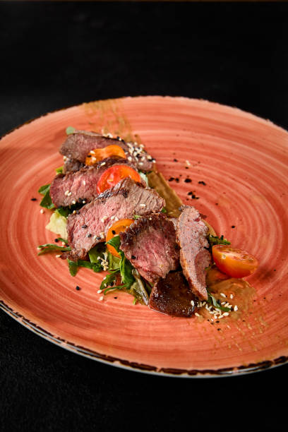 istock Succulent Roast Beef with Tomatoes and Arugula on a Rustic Plate 2161748056