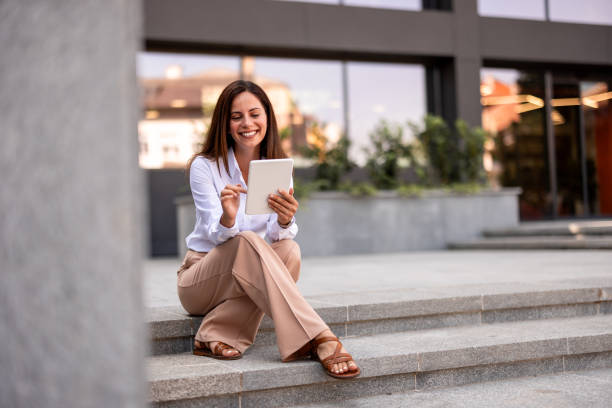 istock Young Professional Woman Using Tablet In Front Of The Office Building 2161748458