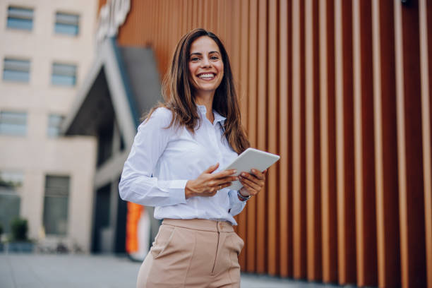 istock Young Professional Woman Using Tablet In Front Of The Office Building 2161748552