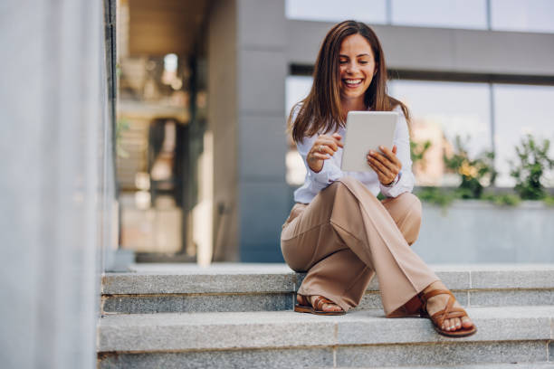 istock Young Professional Woman Using Tablet In Front Of The Office Building 2161748591