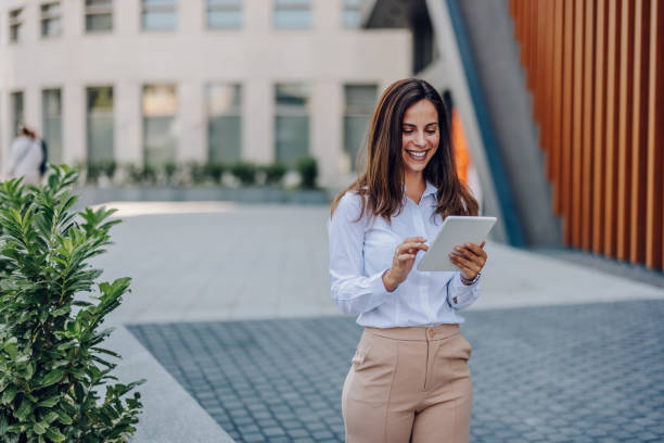 istock Young Professional Woman Using Tablet In Front Of The Office Building 2161748730