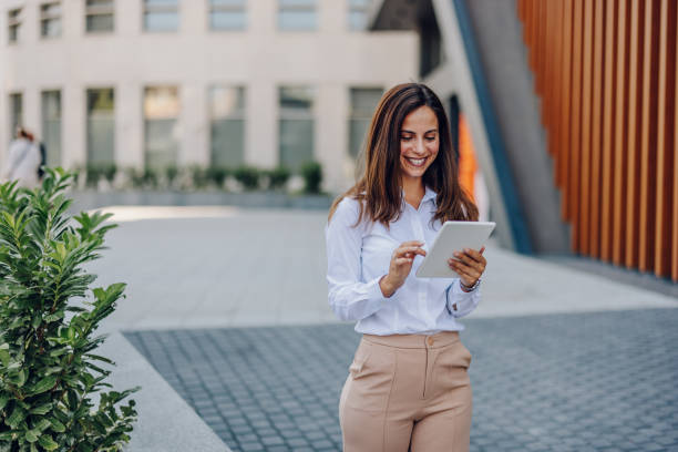 istock Young Professional Woman Using Tablet In Front Of The Office Building 2161748732