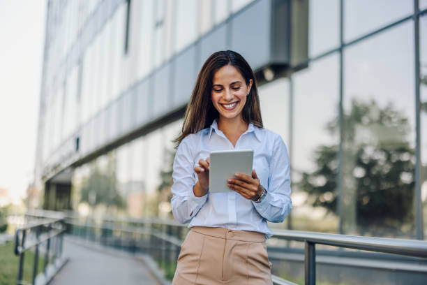 istock Young Professional Woman Using Tablet In Front Of The Office Building 2161748971
