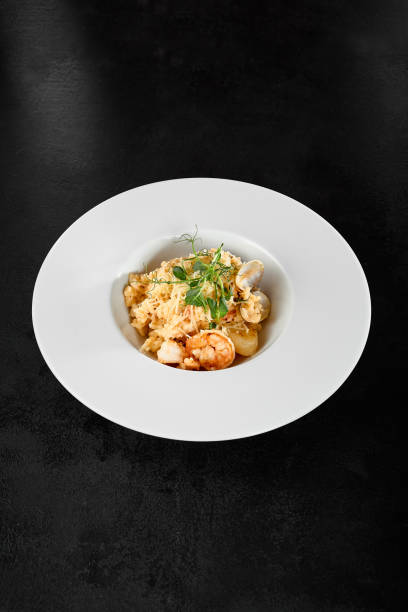 istock Seafood Risotto with Scallops and Shrimp on a Black Background 2161749041