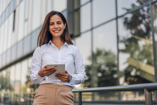 istock Young Professional Woman Using Tablet In Front Of The Office Building 2161749263