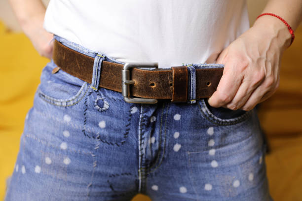 istock A woman's hands on her belt and jeans 2161749296