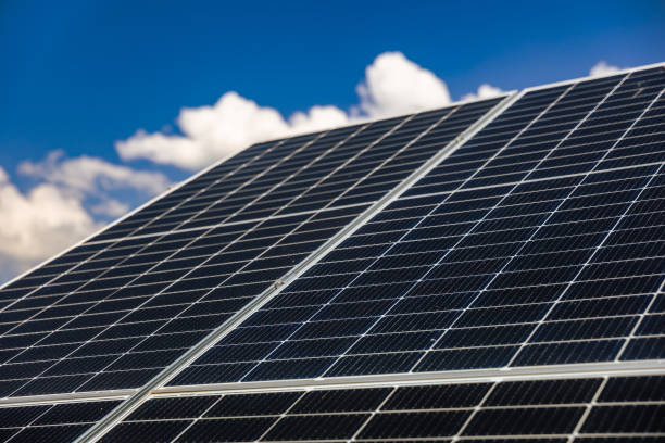 istock Slanted solar panels under the blue sky with white clouds 2161752144