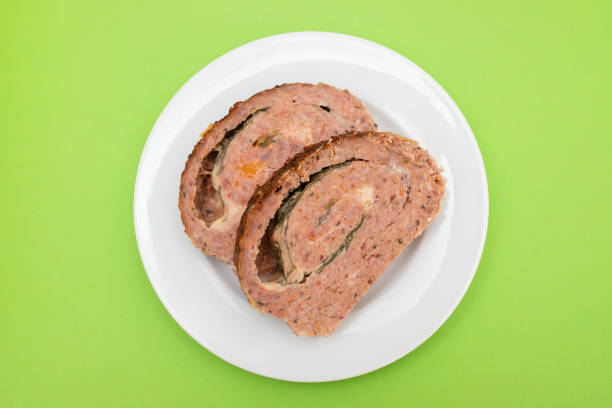 sliced meatloaf with spinach closeup on a white small plate