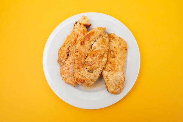 Nerdy male athlete craving for roasted chicken leg on a net in a gym.
