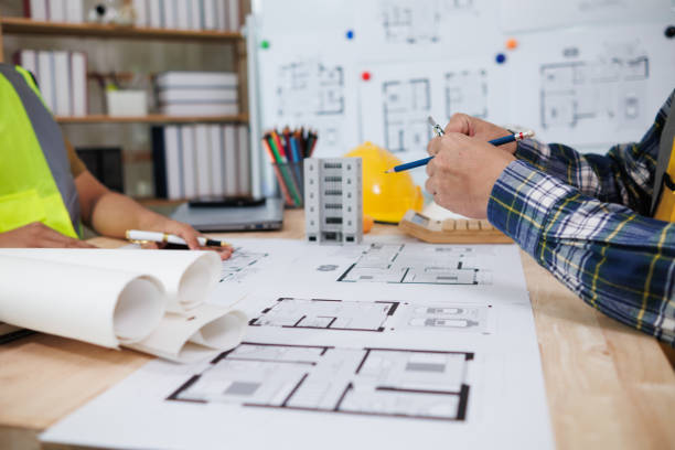istock A team of engineers and architects discuss house plan design and estimate construction prices to suit the construction budget. Checking blueprints and documents with a team of engineers and architects 2161753311