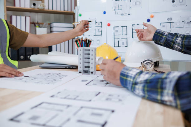 istock A team of engineers and architects discuss house plan design and estimate construction prices to suit the construction budget. Checking blueprints and documents with a team of engineers and architects 2161753320