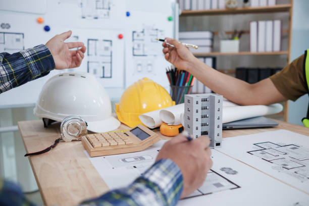istock A team of engineers and architects discuss house plan design and estimate construction prices to suit the construction budget. Checking blueprints and documents with a team of engineers and architects 2161753386