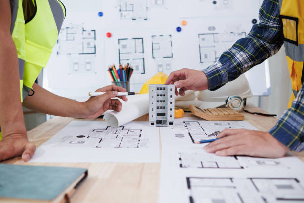 istock A team of engineers and architects discuss house plan design and estimate construction prices to suit the construction budget. Checking blueprints and documents with a team of engineers and architects 2161753519