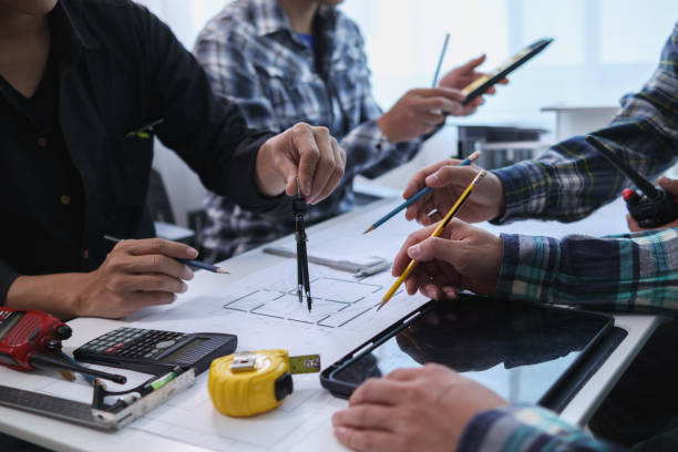 istock A team of engineers and architects discuss house plan design and estimate construction prices to suit the construction budget. Checking blueprints and documents with a team of engineers and architects 2161753562