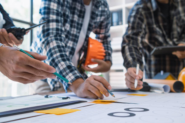 istock A team of engineers and architects discuss house plan design and estimate construction prices to suit the construction budget. Checking blueprints and documents with a team of engineers and architects 2161754622