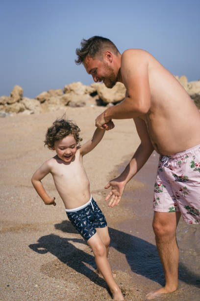 istock A father plays with his son on a Sunny Beach. 2161755335