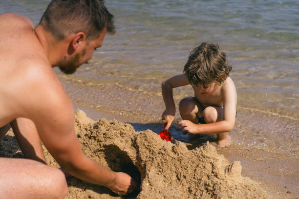 istock A father and son are building a sandcastle on a beach. 2161755463
