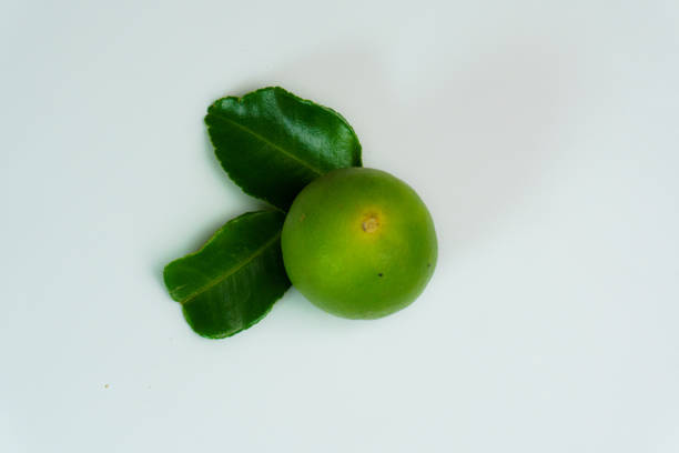 Green lime with green leaf isolated on white background.