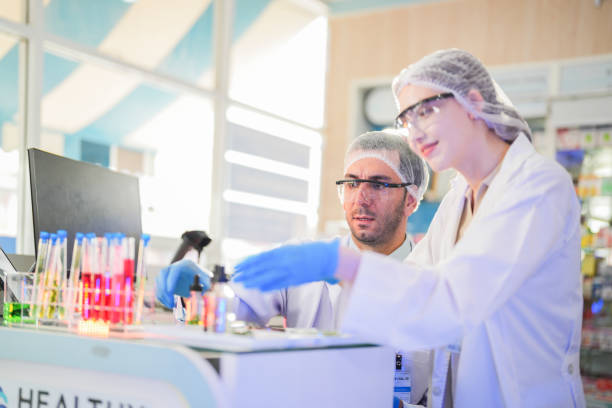istock scientists perform experiments and record data. people arranges equipment with test tubes and chemicals for producing medicine and biochemistry. man hold tubes of chemical liquids and plant samples. 2161765173