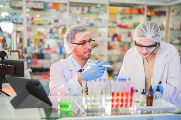 istock scientists perform experiments and record data. people arranges equipment with test tubes and chemicals for producing medicine and biochemistry. man hold tubes of chemical liquids and plant samples. 2161765457