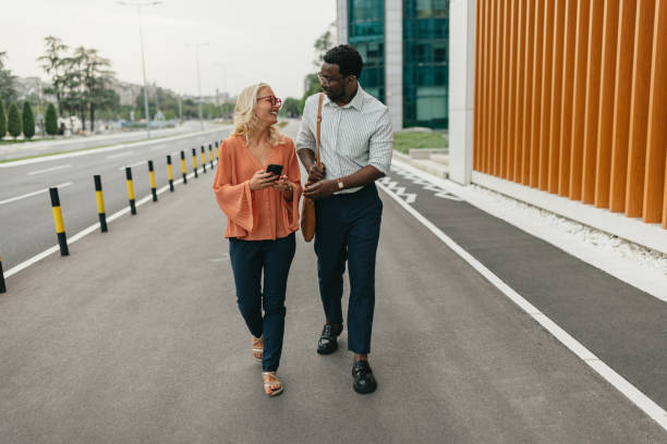 istock Two people walking together while checking their phones 2161765505