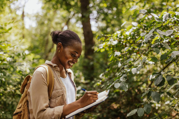 istock Focused individual taking notes in lush green forest 2161766368