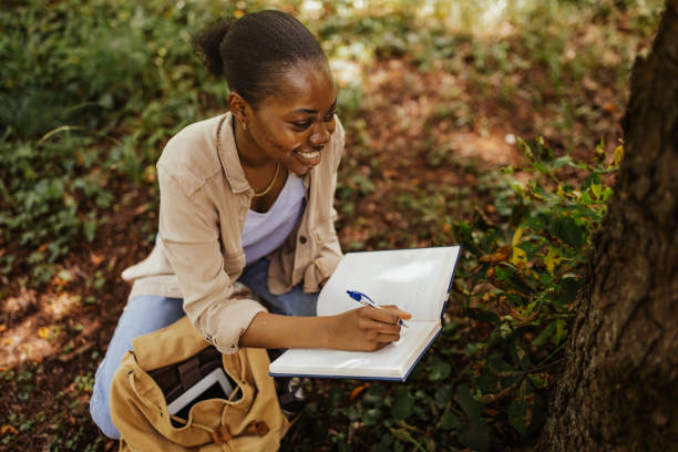 istock Focused woman documenting plant samples in forest. 2161766398