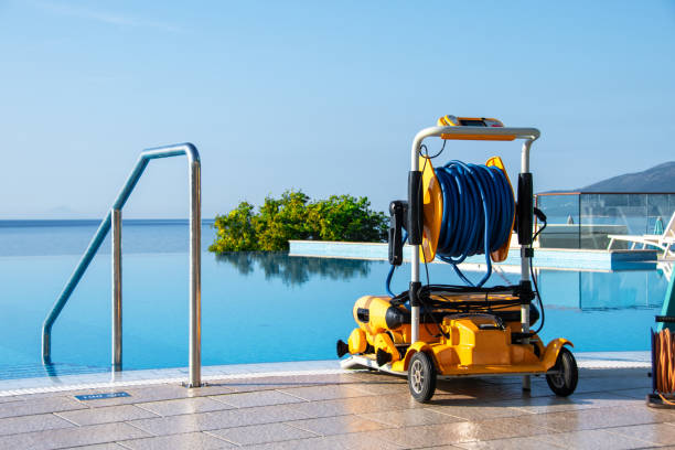istock Modern Robotic Pool Cleaner by Blue Infinity Pool with Tropical Scenery, Outdoor Pool Maintenance Equipment in Sunlight 2161766816