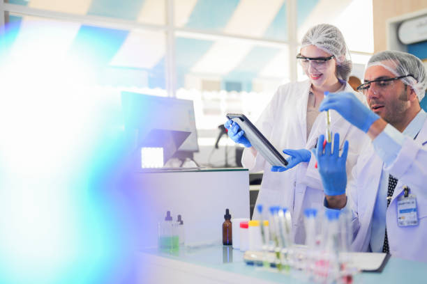 istock scientists perform experiments and record data. people arranges equipment with test tubes and chemicals for producing medicine and biochemistry. man hold tubes of chemical liquids and plant samples. 2161766838