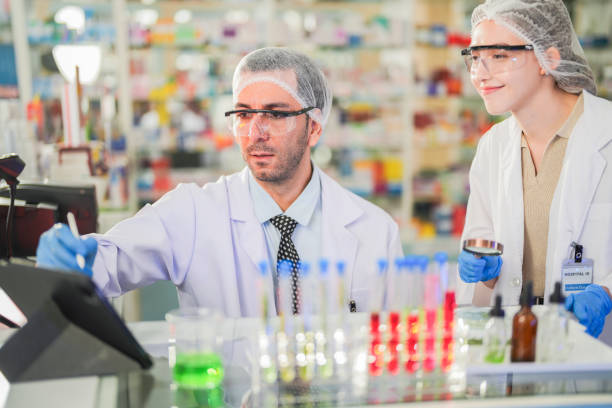 istock scientists perform experiments and record data. people arranges equipment with test tubes and chemicals for producing medicine and biochemistry. man hold tubes of chemical liquids and plant samples. 2161767054