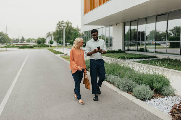 istock Colleagues talking while walking near buildings. 2161767223